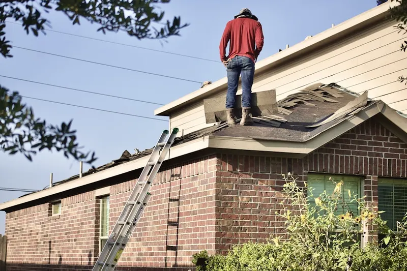 Professional roofer working on a residential roof in South Broadway